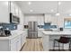 Spacious kitchen featuring stainless steel appliances, white cabinets, and a vibrant blue backsplash at 1036 Barnette Farm Ln, Monroe, NC 28110