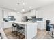 Modern kitchen features a central island, white cabinetry, stainless appliances, and stylish backsplash at 1036 Barnette Farm Ln, Monroe, NC 28110