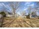 Large backyard featuring a well-manicured lawn, mature trees, and a charming house with a white picket fence at 11918 Parks Farm Ln, Charlotte, NC 28277