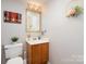 Cozy bathroom with decorative vanity, mirror, and neutral wall paint at 11918 Parks Farm Ln, Charlotte, NC 28277