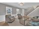 Cozy living room with hardwood floors, neutral paint, and a staircase leading to the upper level at 12325 Parks Farm Ln, Charlotte, NC 28277