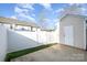 Backyard features a white fence, artificial grass, and a concrete patio and a detached shed at 12584 Jessica Pl, Charlotte, NC 28269