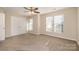 Bright bedroom features three windows, a ceiling fan, a double-door closet, and carpeted flooring at 12584 Jessica Pl, Charlotte, NC 28269