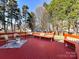 Red deck with bench seating and wooded backdrop offers peaceful outdoor living space at 12907 Mccahan Ln, Huntersville, NC 28078