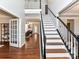 Bright foyer with hardwood floors, staircase, and an open view into the living room with fireplace at 12907 Mccahan Ln, Huntersville, NC 28078