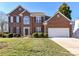 Charming brick two-story home with manicured lawn and attached two car garage in a suburban neighborhood at 12907 Mccahan Ln, Huntersville, NC 28078