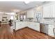 Bright kitchen area with white cabinets and stainless steel dishwasher overlooking living room at 12907 Mccahan Ln, Huntersville, NC 28078