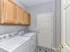 Efficient laundry room with modern machines and convenient overhead cabinet storage space at 12907 Mccahan Ln, Huntersville, NC 28078