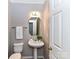 Powder room with pedestal sink, white toilet and door at 12907 Mccahan Ln, Huntersville, NC 28078