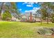 Spacious backyard featuring a deck, brick chimney, mature trees, and lush green lawn at 13501 Misty Dew Ct # 19, Charlotte, NC 28273