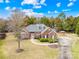 Aerial view of a traditional brick home, with green lawn, mature trees, circular driveway and outdoor structure at 13501 Misty Dew Ct # 19, Charlotte, NC 28273