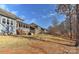 View of the backyard featuring a screened porch and lush, grassy lawn leading to a wooded area at 1412 Great Rd, Waxhaw, NC 28174