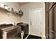 Convenient laundry room with modern appliances, storage shelves, and a utility sink at 1412 Great Rd, Waxhaw, NC 28174