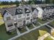 Aerial view of modern townhomes with dark roofing, light siding, and well-maintained lawns at 14139 Loyola Ridge Dr, Charlotte, NC 28277