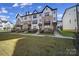 Street view of modern townhomes boasting a mix of brick and siding facades, complemented by well-manicured lawns at 14139 Loyola Ridge Dr, Charlotte, NC 28277