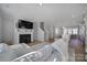 Bright living room with a fireplace, tv, and lots of natural light flowing into the connected kitchen and dining area at 14139 Loyola Ridge Dr, Charlotte, NC 28277