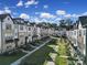 Aerial view of a neat row of townhomes with sidewalks, trimmed lawns, and orderly landscaping at 14139 Loyola Ridge Dr, Charlotte, NC 28277