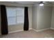 Spacious bedroom with neutral walls and carpeting, featuring a large window with blinds and curtains at 14955 Alexander Place Dr, Huntersville, NC 28078