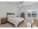 Bright, cozy bedroom with ceiling fan, a large window, and complemented by a wood-finish bed frame and furniture set at 16436 Redstone Mountain Ln, Charlotte, NC 28277