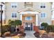 Well-maintained apartment entrance featuring brick accents, manicured bushes, and a covered doorway at 16436 Redstone Mountain Ln, Charlotte, NC 28277