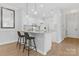 Clean white kitchen with quartz countertops and a breakfast bar featuring modern pendant lights at 16436 Redstone Mountain Ln, Charlotte, NC 28277