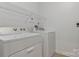 Well-lit laundry room featuring a white washer and dryer set, complemented by a wire shelving unit for optimal storage at 16436 Redstone Mountain Ln, Charlotte, NC 28277