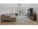 Bright living room with a modern ceiling fan, neutral sofa, stylish fireplace, and doors to the outside at 16436 Redstone Mountain Ln, Charlotte, NC 28277