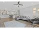 Bright living room featuring an open floorplan, modern ceiling fan, and stylish grey sofa at 16436 Redstone Mountain Ln, Charlotte, NC 28277