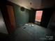 Dark green bedroom with damage to floor at 169 Adams Cir, Candor, NC 27229