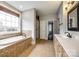 Bright bathroom featuring a soaking tub, a large window, and tile flooring at 1765 Old Clay Hill Rd, York, SC 29745