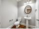 Charming powder room with a pedestal sink, elegant fixtures, and hardwood floors at 1765 Old Clay Hill Rd, York, SC 29745