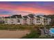 Sunset view of lakefront condos with a pool and sandy beach at 17811 Half Moon Ln # E, Cornelius, NC 28031