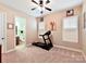 Neutral carpeted bedroom featuring ceiling fan, window shutters, and a treadmill at 2001 Arbor Hills Dr, Indian Trail, NC 28079