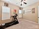 Neutral carpeted bedroom featuring ceiling fan, window shutters, and a treadmill at 2001 Arbor Hills Dr, Indian Trail, NC 28079