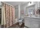 Clean bathroom with a shower/tub combo, white vanity, and floral-patterned curtain at 215 Briana Marie Way, Indian Trail, NC 28079