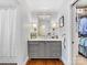 Bathroom featuring gray vanity, stylish mirror, decorative sconces, and a walk-in closet at 2315 Red Fox Trl, Charlotte, NC 28211