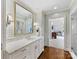 Bathroom with double sinks, white subway tile, marble countertop, and an adjacent gym room at 2315 Red Fox Trl, Charlotte, NC 28211