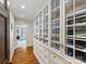 Hallway with custom built-in glass wardrobes and hardwood floors at 2315 Red Fox Trl, Charlotte, NC 28211