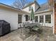 Charming patio with stone pavers, outdoor dining set, and access to the home's interior at 2315 Red Fox Trl, Charlotte, NC 28211