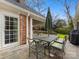 Inviting patio featuring a stone surface and an outdoor dining set under a vibrant blue sky at 2315 Red Fox Trl, Charlotte, NC 28211