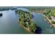 Aerial view of a luxury lakefront home surrounded by lush greenery and serene blue waters at 296 Windemere Isle Rd, Statesville, NC 28677