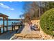 Stone patio and beach access featuring vibrant chairs, walkway, and serene lake views at 296 Windemere Isle Rd, Statesville, NC 28677