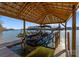 View of the covered boat lift featuring sleek boat, surrounded by serene lake and lush greenery at 296 Windemere Isle Rd, Statesville, NC 28677