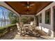 Covered patio area showcasing wood ceiling with fans, stone pillars, and outdoor dining set, with lake view at 296 Windemere Isle Rd, Statesville, NC 28677