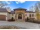 Elegant home entrance featuring a stone archway, custom double doors, and a well-manicured landscape at 296 Windemere Isle Rd, Statesville, NC 28677