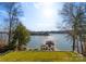 Scenic lake view from a grassy lawn with a covered boat dock and glistening water at 296 Windemere Isle Rd, Statesville, NC 28677