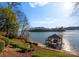 Lush lawn overlooking the lake featuring a private covered boat dock and lift at 296 Windemere Isle Rd, Statesville, NC 28677