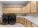 Laundry room featuring built in cabinets, large countertop, sink, and modern washer and dryer set at 296 Windemere Isle Rd, Statesville, NC 28677