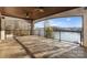 Large covered patio with stone floor, iron railing, and panoramic views of the lake at 296 Windemere Isle Rd, Statesville, NC 28677