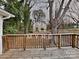 View of the backyard from the wooden deck with various trees and leaves on the ground at 3138 Morson St, Charlotte, NC 28208